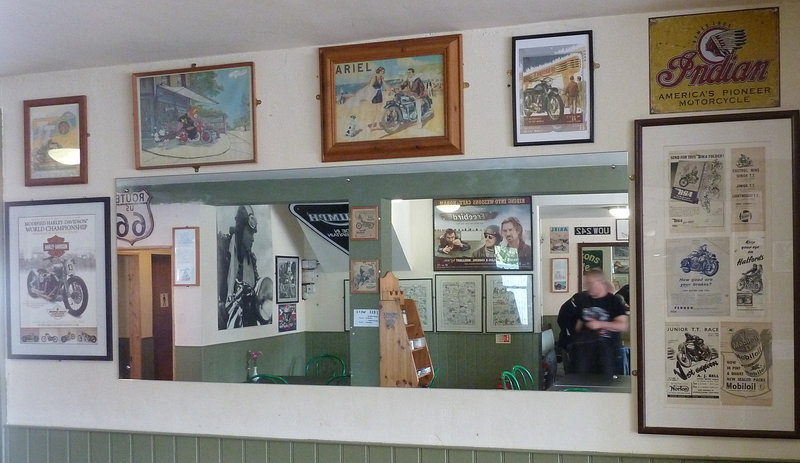 Motorcycle posters and memorabilia. The Gentleman in the goggles is similar to the biker's stone head in first photograph.