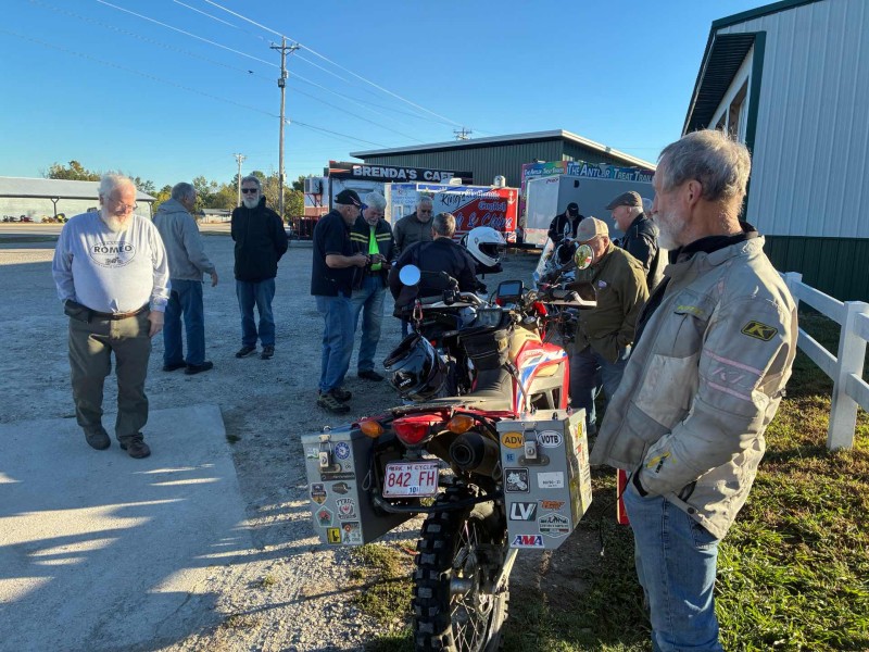 The gang enjoying fellowship before breakfast. Mike R. still in his V Twin saddle. I doubt anyone would steal it. They’d probably come for my KLR if any were stolen. Not.